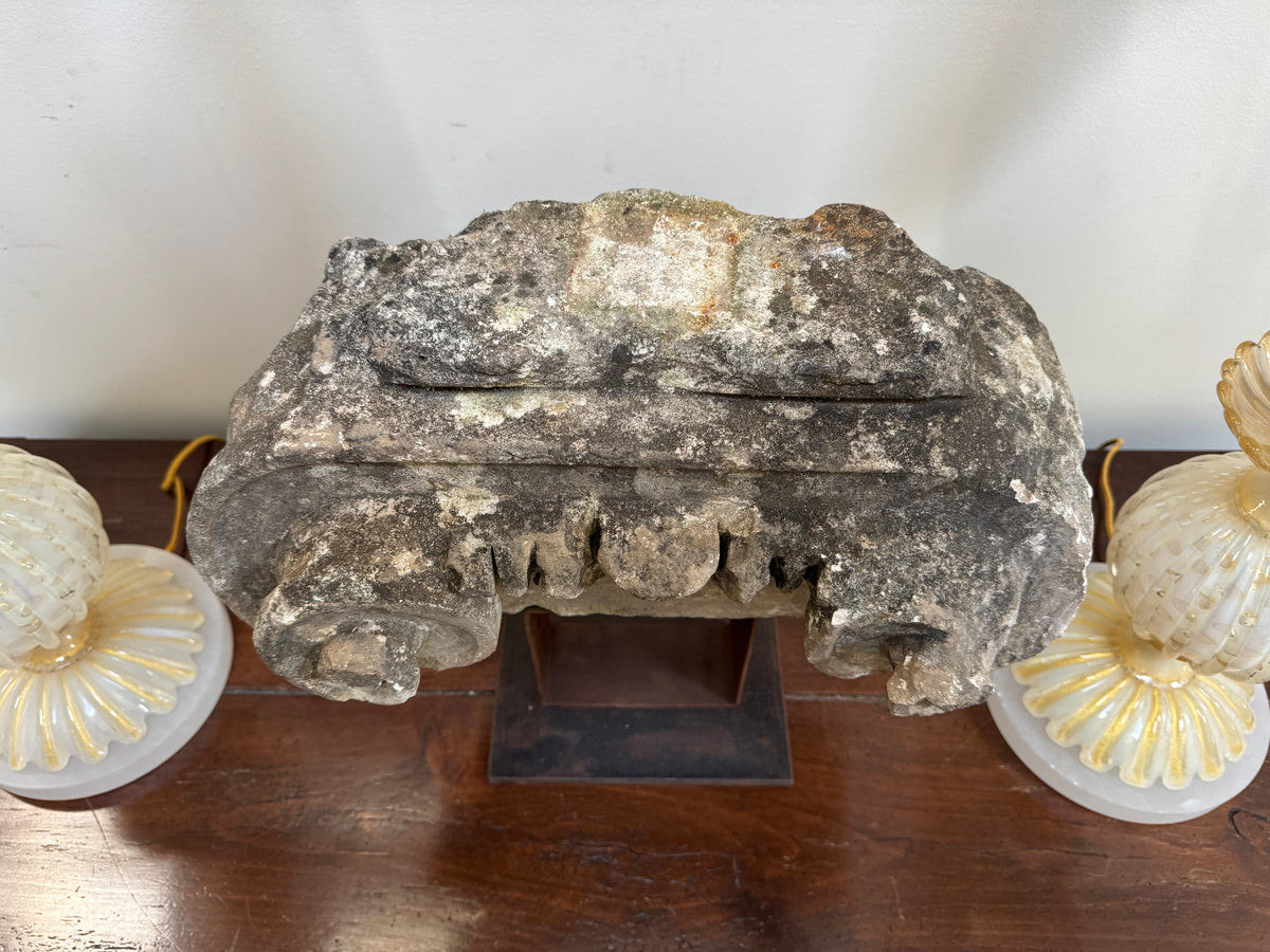 Ancient stone Ionic capital on an iron stand, French